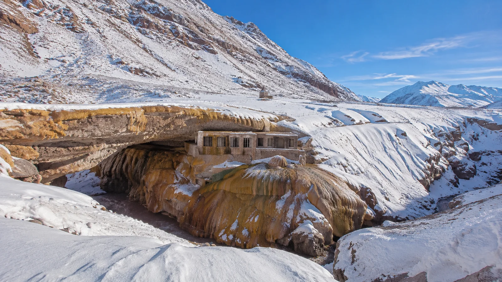Formación mineral de Puente del Inca rodeada por nieve y montañas